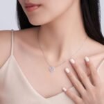 Collana rotonda in oro 18 carati con moissanite e quadrifoglio.