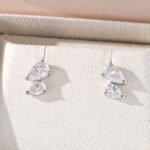 Oorbellen met 3 pootjes en dubbele peervormige Moissanite-steen.