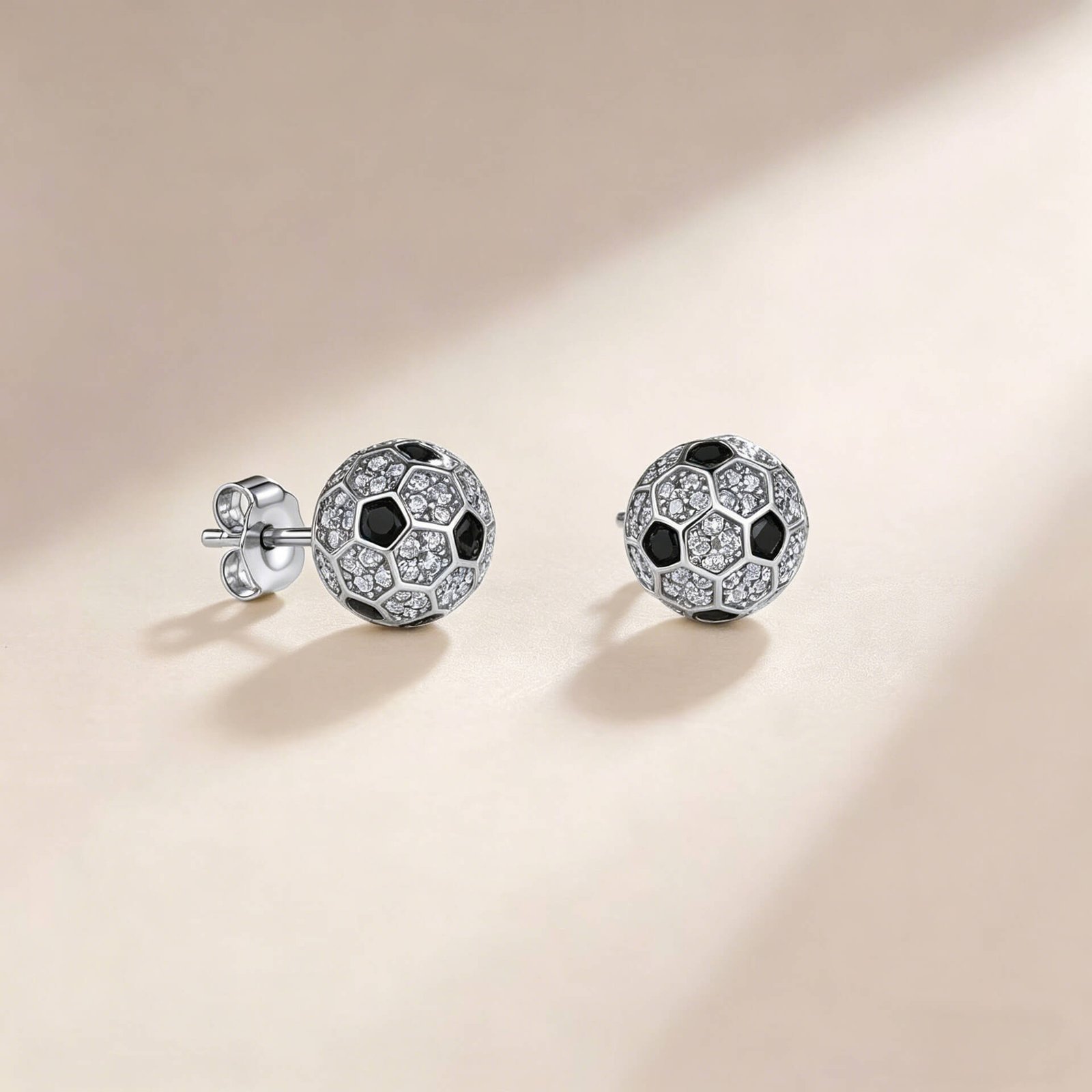 Puces d'oreilles en moissanite ronde, serties sur une monture en forme de ballon de football. Puces d'oreilles en moissanite ronde, serties sur une monture en forme de ballon de football.