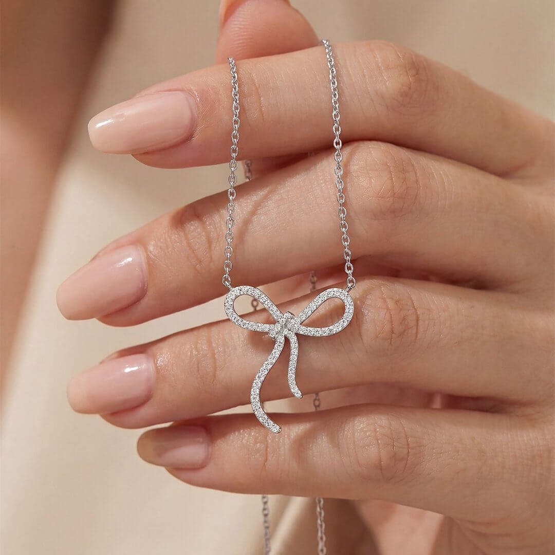 Colar com pingente redondo em formato de laço, cravejado com pavé de moissanita. Colar com pingente redondo em formato de laço, cravejado com pavé de moissanita.
