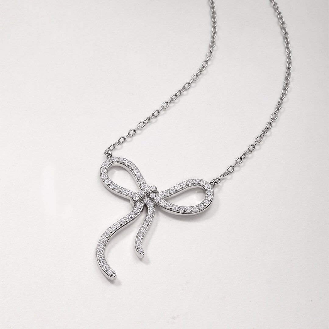 Colar com pingente redondo em formato de laço, cravejado com pavé de moissanita. Colar com pingente redondo em formato de laço, cravejado com pavé de moissanita.