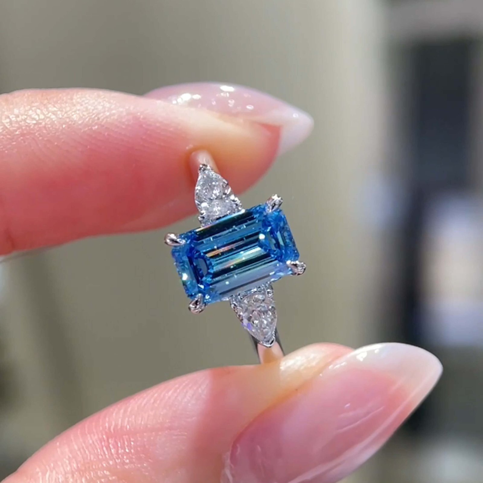 Smaragdgeslepen, in het laboratorium gekweekte blauwe diamanten verlovingsring met drie stenen Smaragdgeslepen, in het laboratorium gekweekte blauwe diamanten verlovingsring met drie stenen