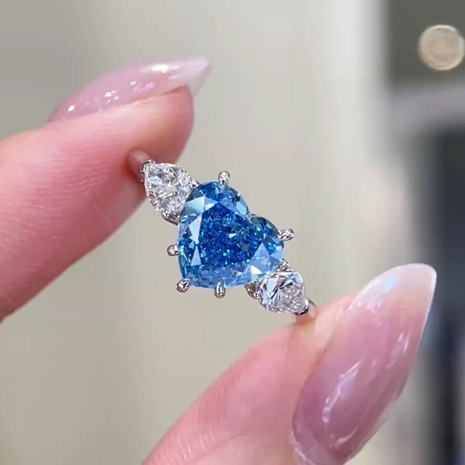 Hartvormige, in het laboratorium gekweekte blauwe diamanten verlovingsring met drie stenen