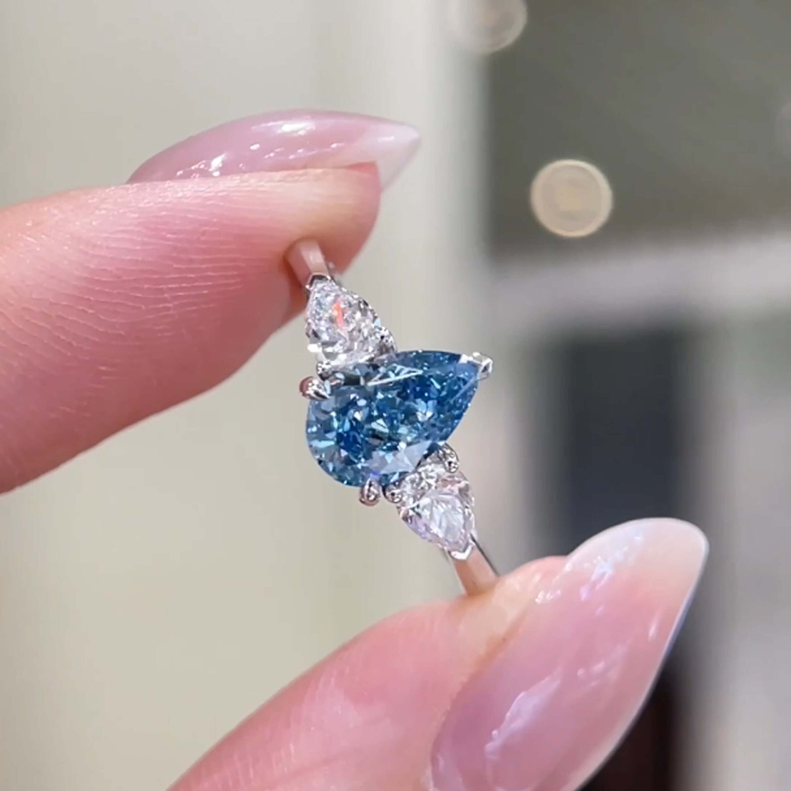 Verlobungsring mit drei Steinen und birnenförmigem, im Labor gezüchtetem blauen Diamanten Verlobungsring mit drei Steinen und birnenförmigem, im Labor gezüchtetem blauen Diamanten