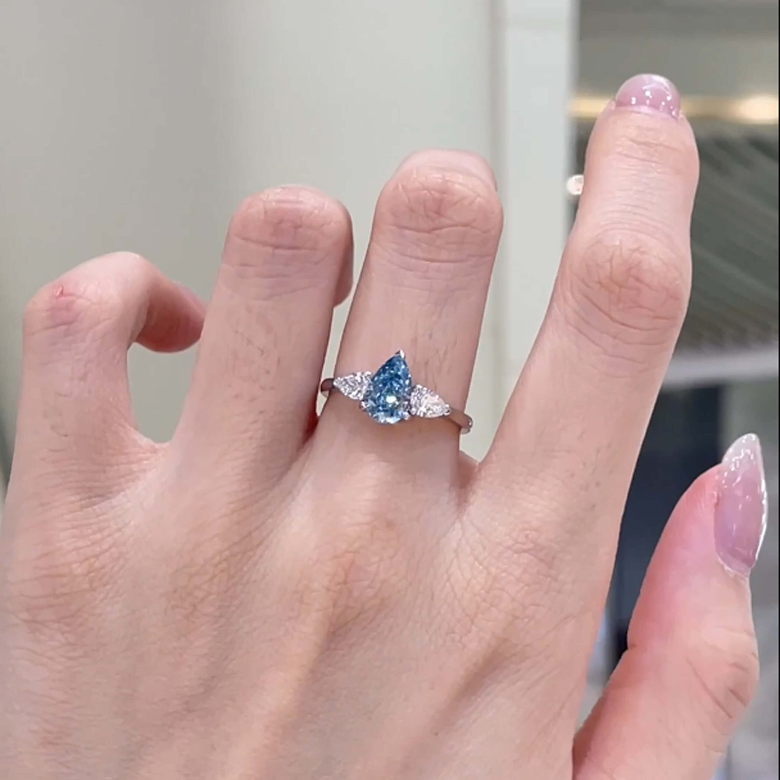 Verlobungsring mit drei Steinen und birnenförmigem, im Labor gezüchtetem blauen Diamanten Verlobungsring mit drei Steinen und birnenförmigem, im Labor gezüchtetem blauen Diamanten