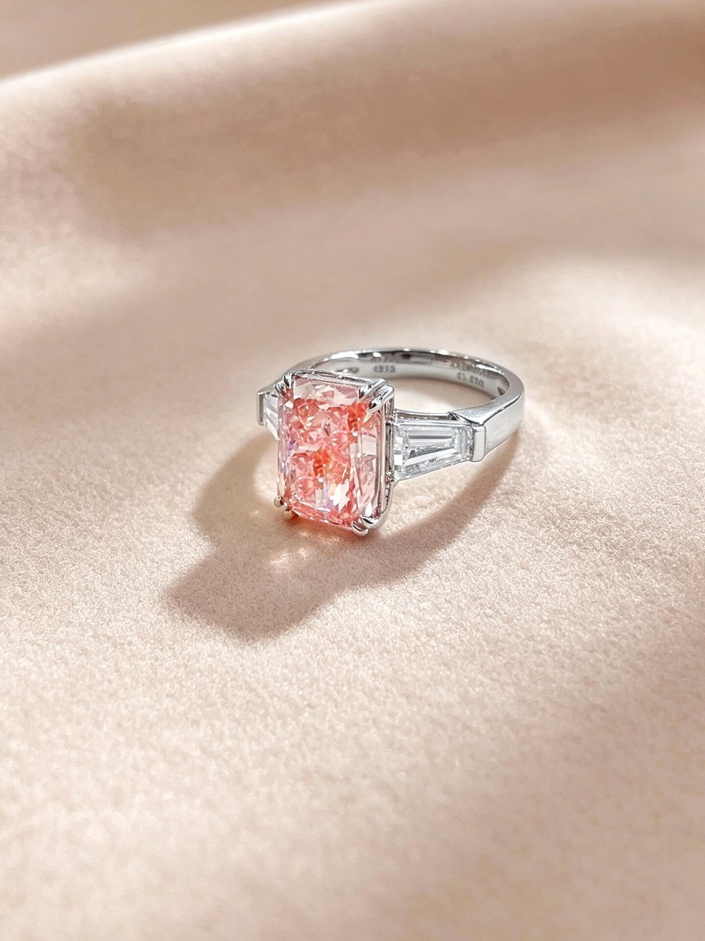 Verlovingsring met drie stenen, gemaakt van in het laboratorium gekweekte roze diamanten met een schitterende slijping. Verlovingsring met drie stenen, gemaakt van in het laboratorium gekweekte roze diamanten met een schitterende slijping.