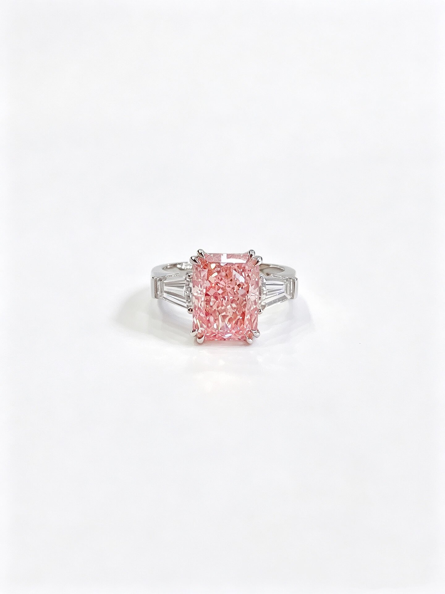 Verlovingsring met drie stenen, gemaakt van in het laboratorium gekweekte roze diamanten met een schitterende slijping. Verlovingsring met drie stenen, gemaakt van in het laboratorium gekweekte roze diamanten met een schitterende slijping.