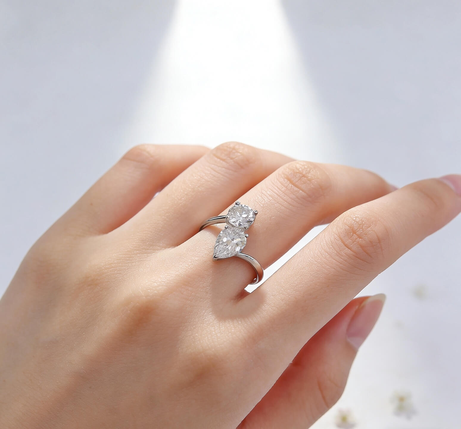 Anillo de compromiso con diamante cultivado en laboratorio, de talla redonda y en forma de pera.