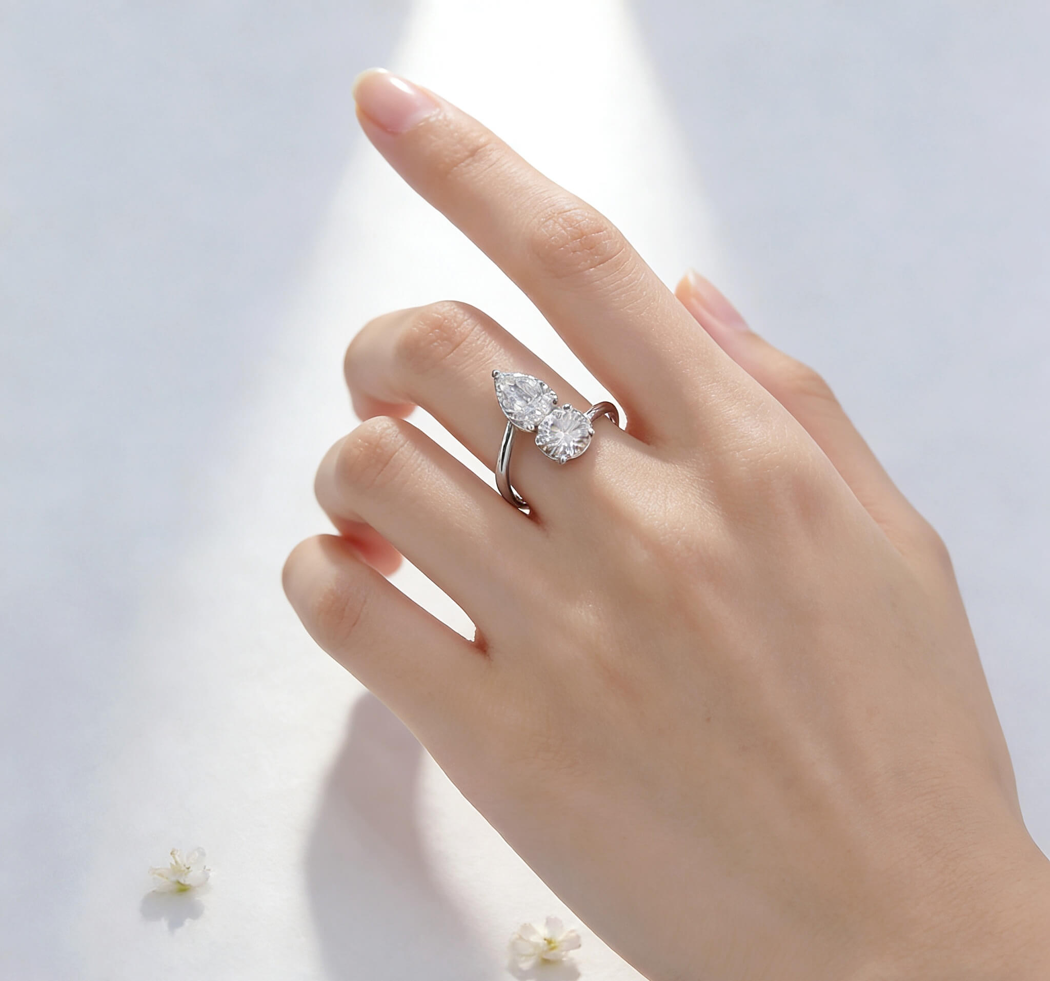 Anillo de compromiso con diamante cultivado en laboratorio, de talla redonda y en forma de pera.