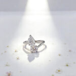 Anillo de compromiso con diamante cultivado en laboratorio, de talla redonda y en forma de pera.