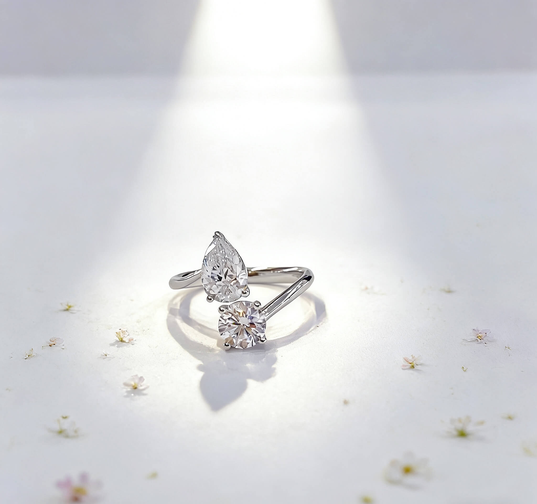 Anillo de compromiso con diamante cultivado en laboratorio, de talla redonda y en forma de pera.