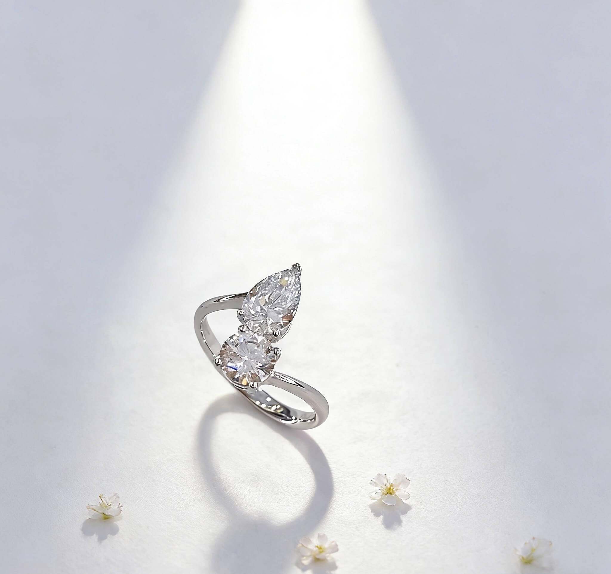 Anillo de compromiso con diamante cultivado en laboratorio, de talla redonda y en forma de pera.